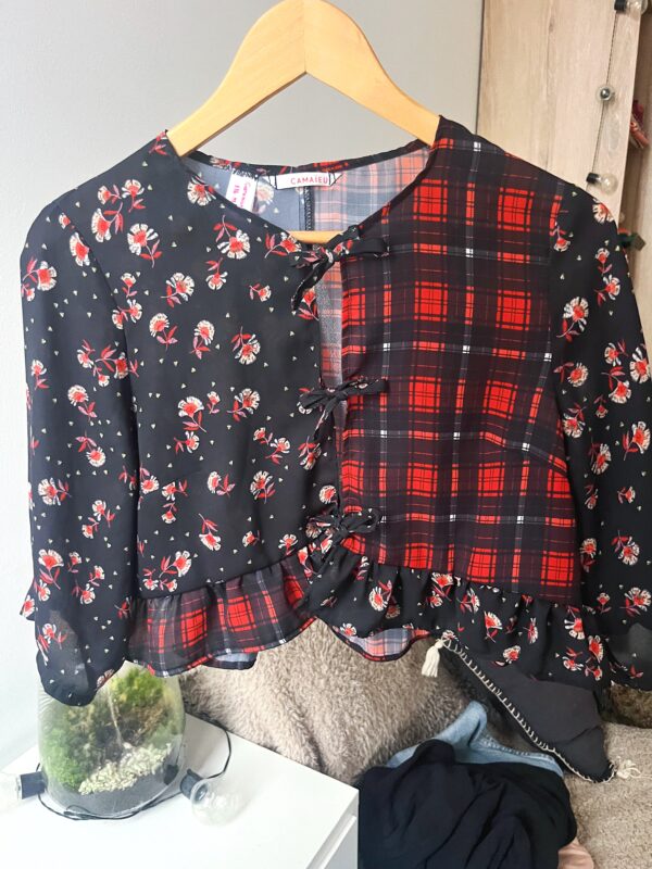 Blouse noire customisée en coton avec volant et liens noués, motifs carreaux et fleurs