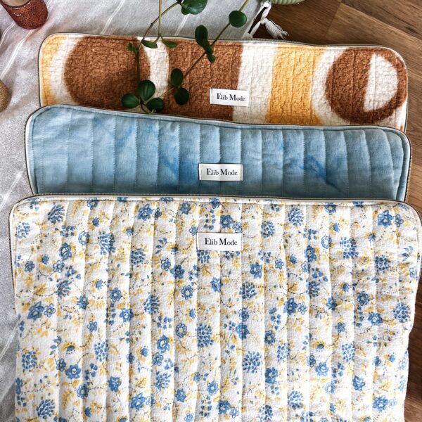 Pochettes d'Ordinateur Upcyclées – Taille Standard 💻 Les pochettes d'ordinateurs upcyclées que je propose sont le fruit de plusieurs heures de travail et de passion. Chaque modèle est conçu à partir de tissus anciens soigneusement sélectionnés, teints et matelassés pour offrir à votre ordinateur ou tablette une protection élégante et écologique. Ce sont des créations uniques, imaginées et réalisées par mes soins, sans aucune production en série. Ces pochettes sont disponibles en trois modèles distincts, chacun ayant une histoire et un design unique. Elles sont parfaites pour une utilisation quotidienne, en plus de protéger vos appareils avec style. Si vous cherchez une pochette à la fois moderne, vintage et éco-responsable, vous êtes au bon endroit ! Modèle 1 : Pochette Bleu Tie & Dye – Une Histoire Familiale 🌿 Un héritage transformé Ce modèle est un hommage à mon arrière-grand-mère, puisque le tissu extérieur provient d’une nappe ancienne qui appartenait à ma famille. Malheureusement, cette nappe a jauni avec le temps. Cependant, avec l’aide de ma mère, nous lui avons donné une seconde vie en utilisant la teinture indigo pour créer un superbe effet tie and dye. Ce procédé a transformé le tissu, offrant une couleur bleu dégradé, parfaite pour un look moderne et vintage. Doublure et finition 💫 J’ai utilisé une chute de tissu vichy rose et blanc pour la doublure, ajoutant une touche de fraîcheur et une harmonie parfaite avec le bleu du tissu extérieur. La fermeture éclair dorée est ajoutée pour une finition élégante, et le matelassage a été soigneusement réalisé pour apporter de la protection et de la douceur. Modèle 2 : Pochette Vintage Marron et Jaune – Pour un Style Rétro 🌻 Un plaid vintage transformé Ce modèle est confectionné à partir d’un ancien plaid appartenant à la grand-mère de mon copain. Le tissu de ce plaid est orné de motifs abstraits marron et jaune, un choix parfait pour un look vintage et chaleureux. Après avoir soigneusement matelassé le tissu extérieur, j’ai ajouté une doublure en coton blanc pour garantir un intérieur doux et résistant. Doublure et détails 🌸 La fermeture éclair dorée ajoute une touche de luxe, et la pochette a été matelassée avec une surpiqure de 2,5 cm pour offrir une protection optimale à vos appareils. Ce modèle est idéal pour ceux qui recherchent un produit élégant, fonctionnel et écologique. Modèle 3 : Pochette Fleurie – Une Création Naturelle 🌼 Un plaid fleuri revalorisé Le troisième modèle est confectionné à partir d’un ancien plaid qui appartenait à la grand-mère de mon copain. Ce plaid blanc, orné de petites fleurs jaunes et bleues, a un charme tout particulier et est un excellent choix pour une pochette pleine de douceur. Ce tissu a ensuite été matelassé pour garantir sa résistance et protéger votre ordinateur ou tablette. Doublure et finition 💖 La doublure est réalisée avec une ancienne serviette de table que j'ai teintée avec de l'indigo pour éliminer les taches. Ce procédé de teinture a permis de créer un joli bleu qui se marie parfaitement avec les fleurs du tissu extérieur. La fermeture éclair dorée vient apporter une finition soignée, et le matelassage a été réalisé pour garantir la sécurité et la protection de vos appareils. Une création qui allie authenticité et élégance. Pourquoi choisir des pochettes upcyclées ? 🌱 L’upcycling consiste à transformer des matériaux et tissus anciens en de nouveaux objets, plus modernes et fonctionnels, tout en préservant leur histoire. En choisissant l’une de ces pochettes d’ordinateur, vous choisissez non seulement un produit unique et esthétique, mais vous contribuez également à une démarche éco-responsable. Ces pochettes sont une solution idéale pour allier écologie et style, tout en donnant une nouvelle vie à des tissus qui auraient autrement été jetés. Le matelassage garantit une protection optimale de vos appareils tout en apportant un design élégant et original. Polyvalence et Utilisation 🛡️ Ces pochettes sont parfaites pour transporter vos ordinateurs portables, mais peuvent également être utilisées pour des tablettes, des documents ou même comme un organisateur pour des accessoires divers comme des câbles, des chargeurs ou des clés USB. Le matelassage épais de chaque pochette garantit une protection contre les chocs et les rayures. Entretien et Durabilité 💧 Pour prendre soin de votre pochette et lui assurer une longue vie, voici quelques conseils : Lavage : Lavez la pochette à la main, de préférence avec de l'eau froide et un savon doux. Repassage : Si nécessaire, repassez à température basse en utilisant un tissu de protection entre le fer et la pochette pour ne pas altérer les motifs et les couleurs.